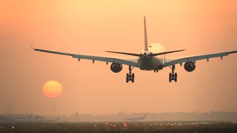 4K Passenger airplane landing during sunrise