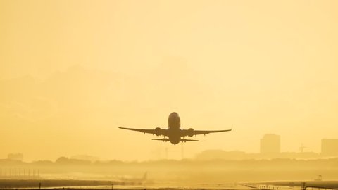 4K Passenger airplane take off during sunrise.
