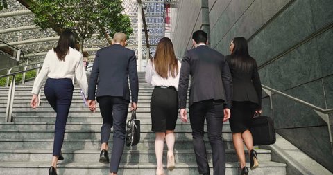 A group of business people of different ethnicities dressed in suits and ties walks proudly after leaving the offices. Concept of: team, success, connection and internationality.
 Video de stock