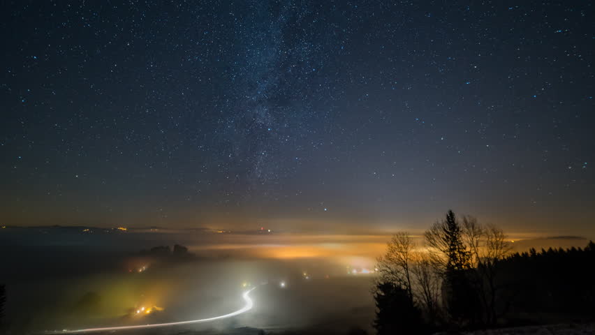 A beatiful Time lapse of the milky way over Sulzberg city in Bavaria Bayern allgau. It was foggy and it looks like waves at night over the city. | Shutterstock HD Video #1011989411