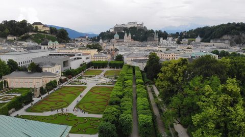 Aerial view of cityscape of Salzburg city, famous Mirabell Gardens, Salzburg Cathedral, old historic Fortress Hohensalzburg and Alps mountains in backgroung - landscape of Austria from above, Europe