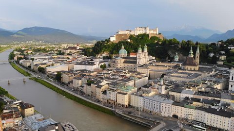 Aerial panoramic view of cityscape of Salzburg city, Salzach River, Salzburg Cathedral, old historic Fortress Hohensalzburg and Alps mountains in backgroung - landscape of Austria from above, Europe