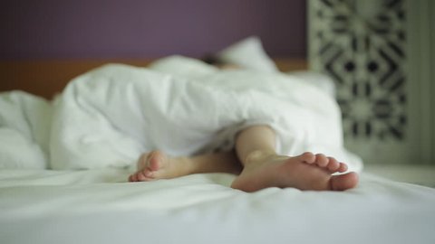 Close-up of the feet sleeping in the bed of a little girl