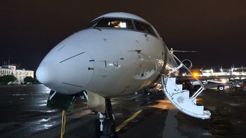 Business jet with the ramp folded down stand on the airfield at night