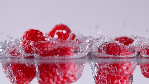 Super slow motion of falling raspberries into water. Filmed on cinema slow motion camera, 1000fps, ProRes 422 HQ codec.