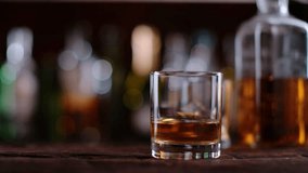 Super slow motion of falling ice cube into whiskey glass. Filmed on cinema slow motion camera, 1000fps, ProRes 422 HQ codec.