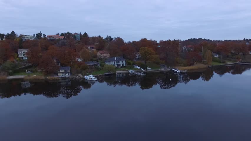 Scandinavia Houses by water with reflections on the water. Stockholm Sollentuna Danderyd Drone view. beautiful day in autumn fall with cloudy skies. lifting shot revealing the landscape Royalty-Free Stock Footage #1012016732