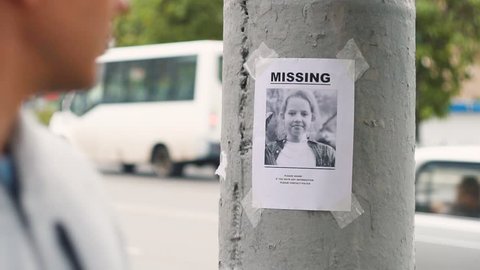leaflet about the missing child hanging on a pole,slow mo