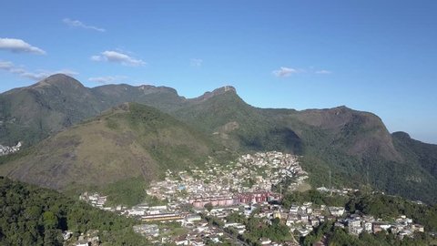 Aerial view of Petropolis, city in the middle of the mountains in Brazil, near Rio de janeiro. Beautiful day with blue sky and sun in the green trees of tropical forest. 