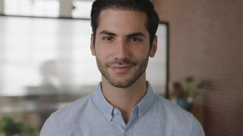 close up portrait of young successful middle eastern businessman looking at camera smiling happy in office workspace background real people series