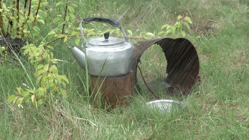 Water pours on top of the kettle. Suburban area. Outside the city. Summertime. 4K video
