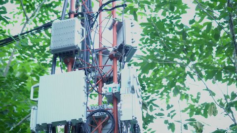 Transmitter at Telecommunication GSM (5G,4G) tower.The cellular phone antennas in city areas.Telecom network base station.Technology for communication.Footage 4k