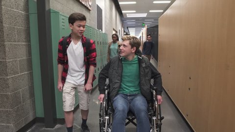 Medium shot of two friends chatting on school corridor