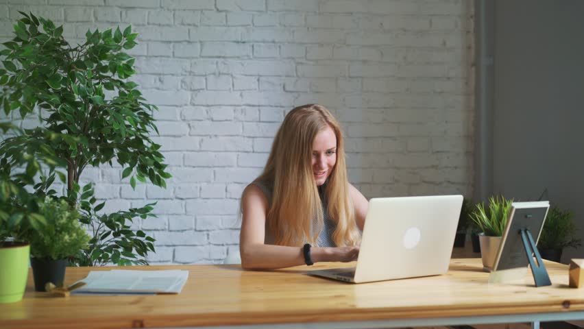 Happy woman feeling excited looking at laptop screen sitting at workplace Royalty-Free Stock Footage #1012053995