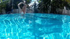 Young woman swims and dives in the beautiful swimming pool, Diving in the private swimming pool, Video clip