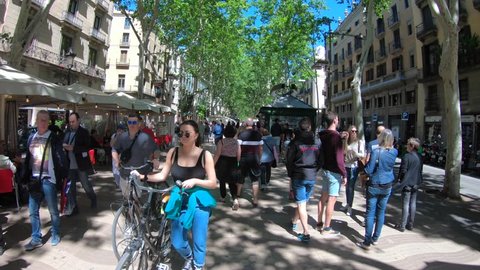 Barcelona, Spain - May 14, 2018: Stabilized walking footage along La Rambla famous street with crowds of locals and tourists, on a sunny day