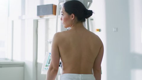 In the Hospital, Topless Female Patient Undergoes Mammogram Screening Procedure. Healthy Young Female Does Cancer Preventive Scan. Modern Hospital with High Tech Machines. Shot on RED EPIC-W 8K Camera