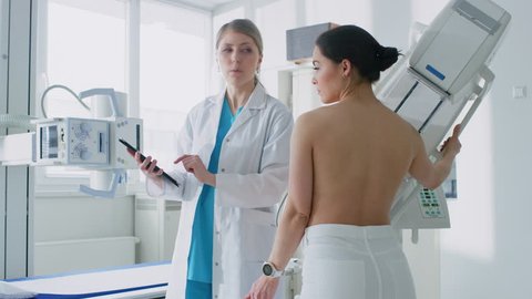 In the Hospital, Female Patient Listens to Mammography Technologist / Doctor Uses Tablet Computer, Explains Importance of Breast Cancer Prevention. Mammography Procedure. Shot on RED EPIC-W 8K Camera 