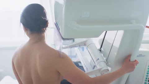 In the Hospital, Back View Shot of Topless Female Patient Undergoing Mammogram Screening Procedure. Healthy Young Female Does Cancer Preventive Mammography Scan. Shot on RED EPIC-W 8K Camera.