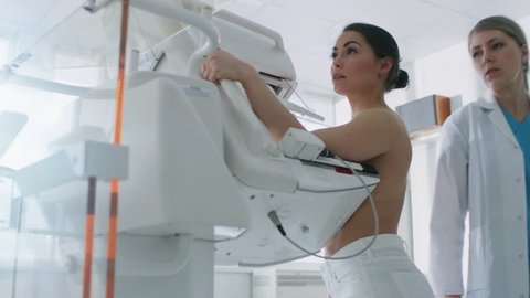 In the Hospital, Mammography Technologist / Doctor Pushes Button on Mammogram Machine Activating Female Patient Scan. Friendly Doctor Explains Importance of Breast Cancer Prevention Screening. 4K UHD.