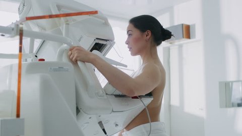 In the Hospital, Portrait Shot of Topless Female Patient Undergoing Mammogram Screening Procedure. Healthy Young Female Does Cancer Preventive Mammography Scan.  Shot on RED EPIC-W 8K Camera.