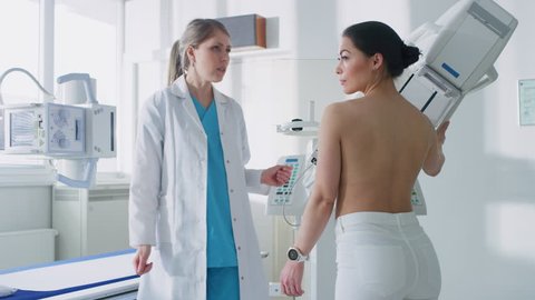 In the Hospital, Mammography Technologist / Doctor adjusts Mammogram Machine for a Female Patient. Friendly Doctor Explains Importance of Breast Cancer Prevention Screening. Shot on RED EPIC-W 8K.