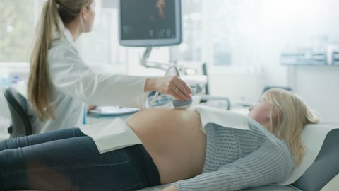 In the Hospital, Obstetrician Uses Transducer for Ultrasound/ Sonogram Screening / Scanning Belly of the Pregnant Woman.  Shot on RED EPIC-W 8K Helium Cinema Camera.