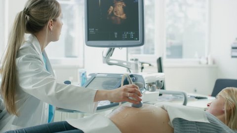 In the Hospital, Pregnant Woman Getting Sonogram / Ultrasound Screening / Scan, Obstetrician Checks Picture of the Healthy Baby on the Computer Screen. Shot on RED EPIC-W 8K Helium Cinema Camera.