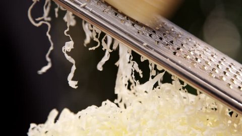 Chef grating parmesan cheese for pizza, close up