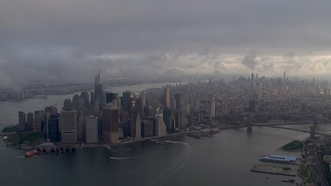 Aerial day time establishing shot of morning fog low cloud cover above New York City Manhattan skyline. Skyscraper tower tops hidden in weather pattern clouds