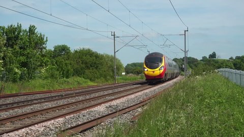 Northamptonshire,UK - June 7, 2018: A Virgin Trains Pendolino tilting electric express passenger train traveling north at speed on the West Coast mainline railway in Northamptonshire England.