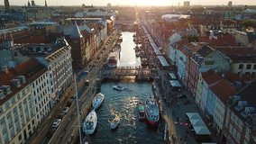 Amzing Backlight sunset footage from Copenhagen, Denmark. bridge in Nyhavn New Harbour canal and entertainment district. Aerial Video footage view from the top. forward movement. Sunset golden light