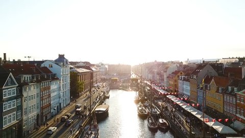 BAcklight sunset footage from Copenhagen, Denmark. bridge in Nyhavn New Harbour canal and entertainment district. Aerial Video footage view from the top. forward movement. Sunset golden time light