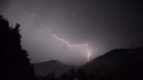 Extreme weather and thunderstorm. Rain, hail and lightning. Dramatic Electric Lightning on Mountain. Thunderstorm with flashing lightning at night. Lighting storms