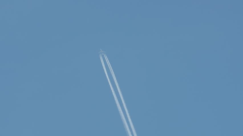 Jet plane flying high in the sky, leaving a white trail. | Shutterstock HD Video #1012093994