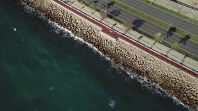 Aerial flying shot following cars on the highway alongside a rocky coast. Stock. Aerial view of Coastline along and highway