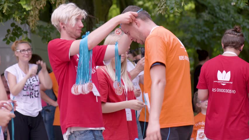 WROCLAW; POLAND - JUNE 9; 2018: City South Park; Run of Awareness about Rare Diseases. The Foundation "I can help". People adults and children are running. Rewarding participants in a marathon. | Shutterstock HD Video #1012111949