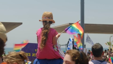 Tel Aviv / Israel 8 June 2018 -  Gay Pride Parade Tel Aviv. Girl sitting on the shoulder of father hanging LGBT flag for rights israeli jews that have fun