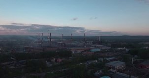 Top view, AERIAL: highway and industrial plant. Air pollution from industrial plants. Pipes throwing smoke in the sky at sunset