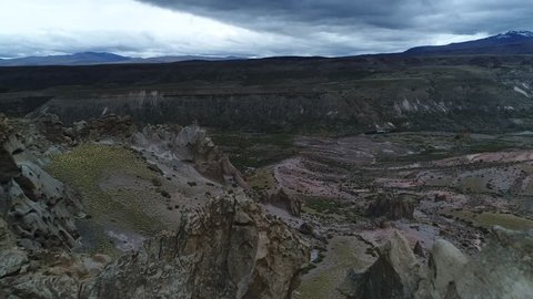 Rocky eroded natural statues of surroundings of Los bolillos, red eroded rock formation. Aerial scene going backwards passing above strange formations starting with view of varvarco valley. Patagonia