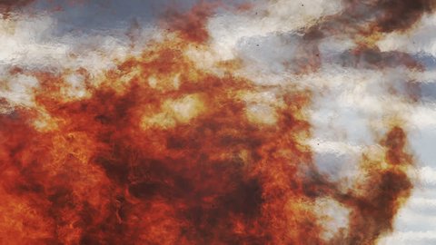 Close Up Shot Of Raging Wild Red Fire Flames Against A Cloudy Sky With Heat Haze.