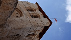 Roof of the Holy Sepulcher Church in Jerusalem with flying flag. The Holy Sepulchre Church and Empty Tomb the sacred places for all Christians. Calvary also located there. Vertical format video.