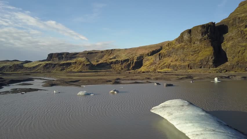 Iceland Glacier Solheimajökull View from Above by a Drone. Glacier Lake with iceberg and rock formations in the background shown from a unique bird