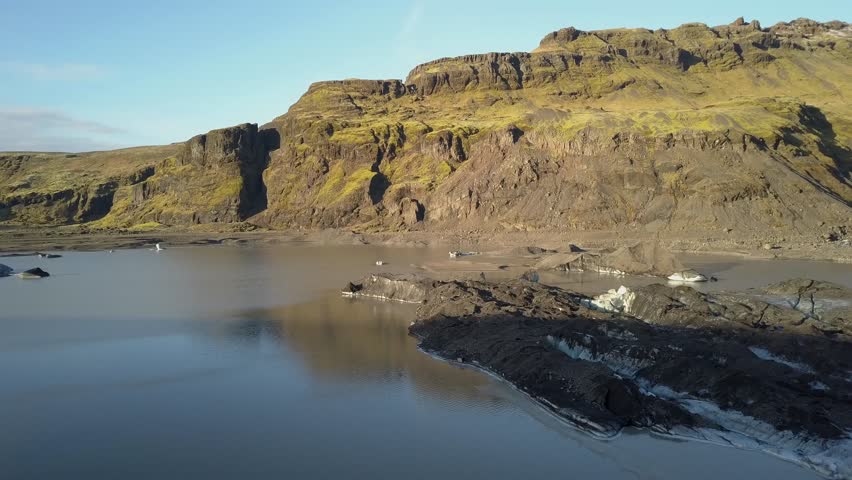 Iceland Glacier Solheimajökull View from Above by a Drone. Glacier Lake with iceberg and rock formations in the background shown from a unique bird