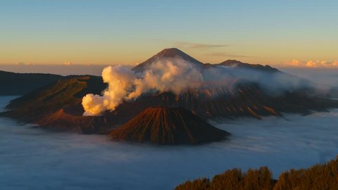Timelapse of rolling cloud and smoke against mountain during sunrise in Bromo, Indonesia