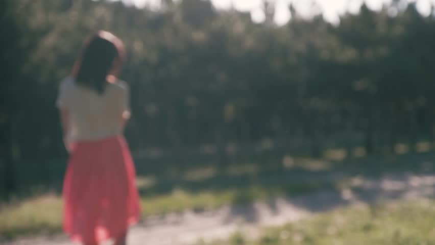 An unfocused silhouette of a young beautiful woman, who puts her hands behind her head