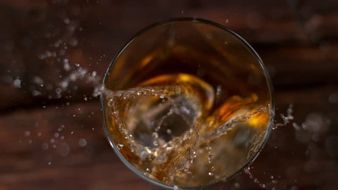 Ice dropped into glass of whisky in super slow motion. Shot with high speed cinema camera, 1000fps.