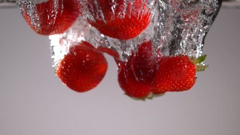 Strawberries falling into water in super slow motion. Shot with high speed cinema camera, 1000fps.