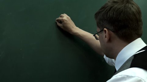 401K. The man in glasses writes on the blackboard