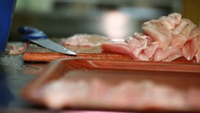 The cook cuts the chicken breast in half, raw chicken, chef cooks chicken breasts, poultry meat, diet meat 